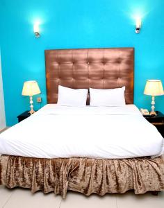 um quarto com uma cama grande e uma parede azul em Premier inn Mall Lahore em Lahore