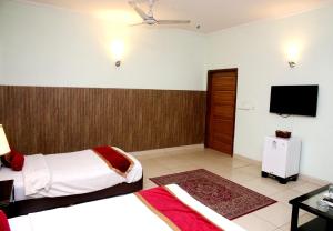 Habitación de hotel con 2 camas y TV de pantalla plana. en Premier inn Mall Lahore, en Lahore