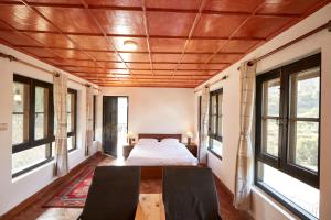 a bedroom with a bed and two chairs at Bandipur Bliss-Apartment in Bandipur