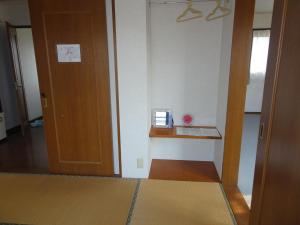 a room with a door and a shelf and a table at Guesthouse Gifu SUAI in Gifu