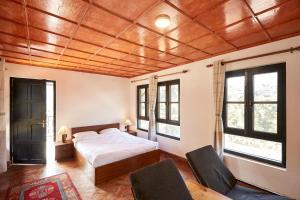 a bedroom with a bed and two chairs at Bandipur Bliss-Apartment in Bandipur