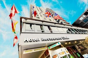 un restaurante de hotel con banderas en la parte superior de un edificio en Hotel Linde - 24h Self Check-in, en Baden