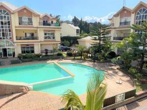 a large swimming pool in front of a building at Appartements - Le Paradisier Ambatobe in Antananarivo