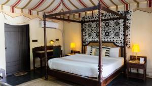 a bedroom with a canopy bed and a desk at 16 Bedouin in Hosūr