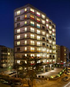 un edificio alto con muchas ventanas por la noche en The Leos Residence, en Estambul