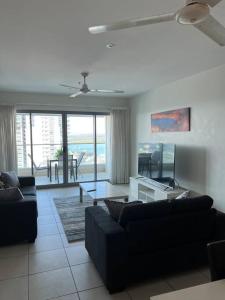 a living room with two couches and a dining room at Above & Beyond (21st floor two bedrooms apartment) in Darwin
