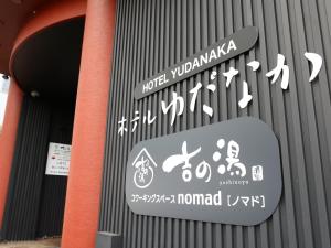 ein Schild an der Seite eines Gebäudes mit Schildern in der Unterkunft Hotel Yudanaka in Yamanouchi
