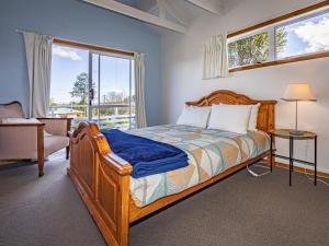 a bedroom with a bed and a large window at Ariki - National Park Holiday Home in National Park