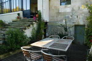 a table and chairs on a patio with stairs at Chambres d'Hôtes Villa Gael in Angoulême