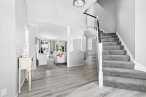 a staircase in a white home with a stair case at Voyagers Resort - Stunning home! in Banksia Beach