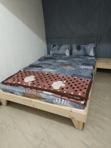 Cette chambre comprend un lit avec un cadre en bois. dans l'établissement REVA ROOM'S, à Rājpīpla