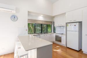 a kitchen with white cabinets and a white counter top at Rainbow Surf 1 in Rainbow Beach