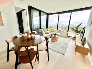 a living room with a table and a couch at Rest Skygarden Collection in Glen Waverley