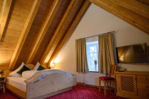Schlafzimmer mit einem Bett und einem Flachbild-TV in der Unterkunft Naturglück Inselmühle in München