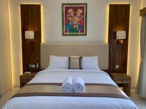 a bedroom with a bed with two towels on it at Betesda Guest House in Canggu