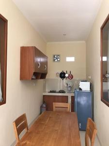 a kitchen with a wooden table and a blue refrigerator at Betesda Guest House in Canggu