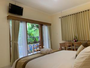 a bedroom with a bed and a large window at Betesda Guest House in Canggu +66 photos