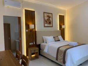 a hotel room with a bed and a table and a room at Betesda Guest House in Canggu