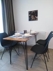 a wooden table with chairs and plates and glasses on it at Hotel boutique Danifeld Inn in Voronet