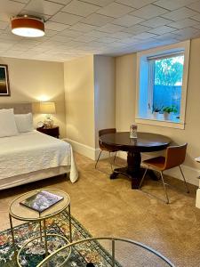 um quarto com uma cama, uma mesa e uma janela em Dougan Suites em Portland