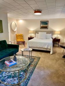 a hotel room with a bed and a couch and tables at Dougan Suites in Portland