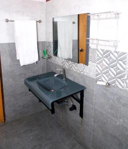 La salle de bains est pourvue d'un lavabo vert et d'un miroir. dans l'établissement Premier inn Mall Lahore, à Lahore
