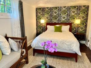 Dougan Suites في بورتلاند: غرفة نوم مع سرير مع زهور أرجوانية عليه