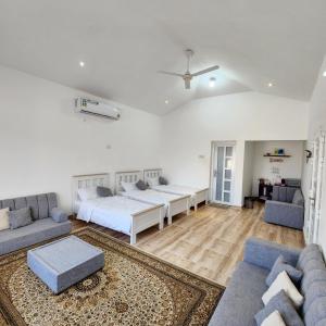 Dawwah的住宿－Wadi Bani Khalid - Al Joud Green Hostel，一间带两张床和一张沙发的客厅