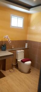 ein Bad mit einem WC und einem Fenster in der Unterkunft Phoo Na Resort in Chiang Mai