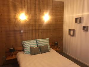 ein Schlafzimmer mit einem Bett mit zwei Lichtern an der Wand in der Unterkunft Les Marmottes 2 in Orcières