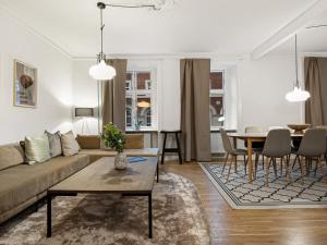 Sanders Stage - Enchanting Four-Bedroom Apartment Near Nyhavn في كوبنهاغن: غرفة معيشة مع أريكة وطاولة