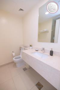 La salle de bains est pourvue de toilettes, d'un lavabo et d'un miroir. dans l'établissement 5 bedroom Villa - Dubai Hills, à Dubaï