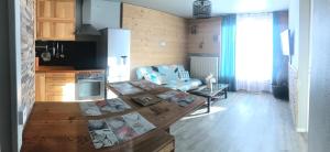 a kitchen and living room with a table and a couch at Les Marmottes 2 in Orcières