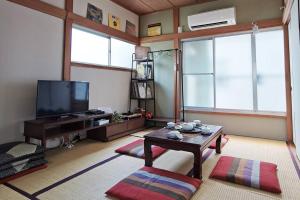 a living room with a table and a tv at Otsuka House in Tokyo