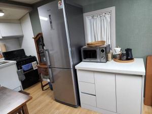 a kitchen with a refrigerator and a microwave on a counter at Goeunjeong in Gwangju