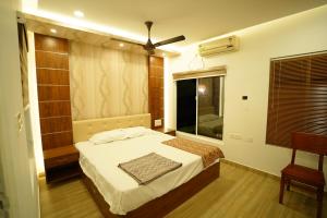 Schlafzimmer mit einem Bett und einem Fenster mit einem Ventilator in der Unterkunft MARARI FARM HERITAGE INN in Mararikulam