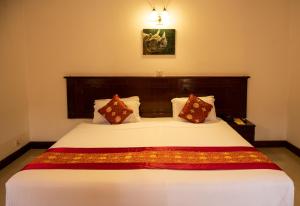 a bedroom with a large white bed with two pillows at Buddha Maya Garden by KGH Group in Rummindei