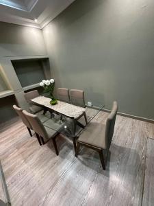 a dining room with a glass table and chairs at Townhouse on 6526 Boiketlo Street, Golfview in Mahikeng