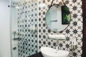 baño con espejo y lavabo en MICHELIA APARTMENT, en Hanói