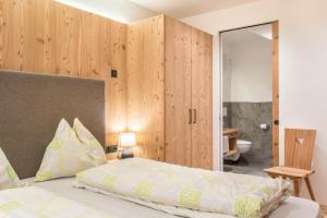 a bedroom with a bed and a large mirror at Guntschöllerhof Hochwart in Völs am Schlern