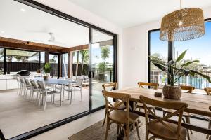 an open kitchen and dining room with a table and chairs at Coorumbong 16 - 5 bedrooms in Mooloolaba