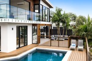 a house with a swimming pool in front of it at Coorumbong 16 - 5 bedrooms in Mooloolaba
