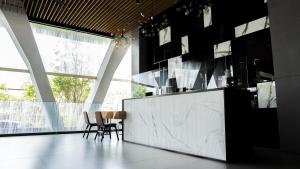 een keuken met zwarte muren en een marmeren aanrecht en stoelen bij Menara One Hotel by Menara Santosa in Kartosuro