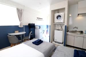um pequeno quarto com 2 camas e uma cozinha em パークサイドモリ em Motobu