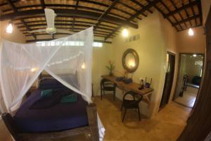a bedroom with a bed with a mosquito net at The Spice House Mirissa in Mirissa