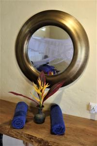 a mirror on top of a wooden table with a vase at The Spice House Mirissa in Mirissa