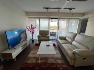een woonkamer met een bank en een tafel bij Luxury Waterfront Stay 1bdr (breathtaking Views) in Darwin