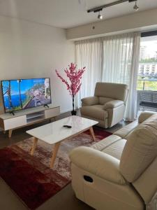 een woonkamer met een bank en een tv bij Luxury Waterfront Stay 1bdr (breathtaking Views) in Darwin