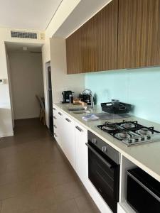 een keuken met een fornuis en een aanrecht bij Luxury Waterfront Stay 1bdr (breathtaking Views) in Darwin