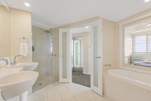 uma casa de banho com 2 lavatórios, uma banheira e um chuveiro em 2BR Oceanview Penthouse @ Mantra Salt Resort by uHoliday em Kingscliff